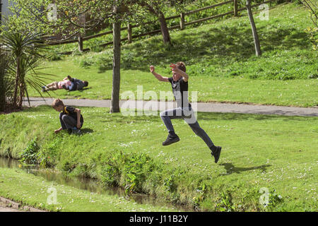 Junge-Jumping über einen Bach Kind Boys spielen körperliche Anstrengung energetische Energy Park Brook Kindheit Adventure Challenge Stockfoto