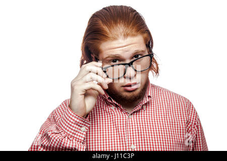 nachdenklich denken bärtige Readhead Geschäftsmann mit rotem Hemd und Sommersprossen Gläser halten und Blick in die Kamera. Studio gedreht isoliert auf weiss. Stockfoto