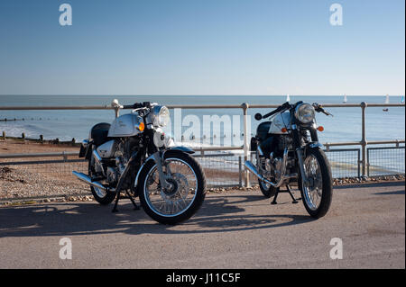 Zwei Royal Enfield Bullet Motorräder parken vor dem Strand in Großbritannien Stockfoto