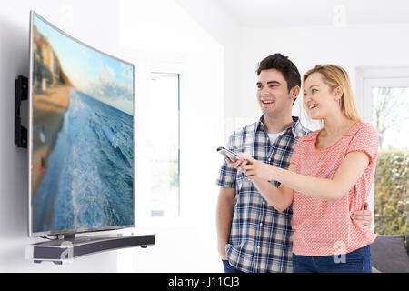 Junges Paar mit neuen Bogensieb Fernsehen zu Hause Stockfoto