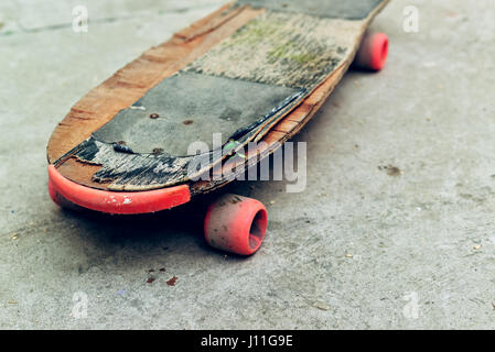 Alten verwitterten Skateboard auf Betonoberfläche, aufgegeben in Skate-Park, selektiven Fokus Stockfoto