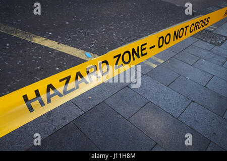 Gefahrenbereich Polizei Band auf Bürgersteig, London England United Kingdom UK Stockfoto