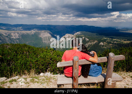 verbinden Sie reisen und entspannen Sie sich in Bergen. Paar sitzen auf Bank. Hinten Sie Ansicht von. Montenegro, Durmitor Stockfoto