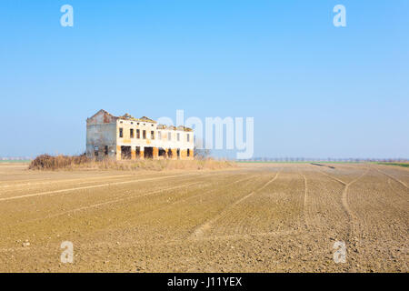 Italienische Landschaft aus Po River Lagune. Gepflügten Felder mit Fluchtlinien. Verlassenen Lagerhaus Stockfoto