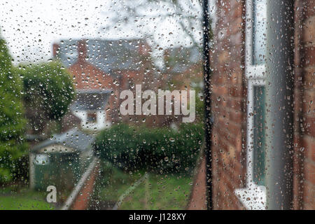 Schlechtes Wetter. Blick durch ein Fenster mit Regen fällt auf, um es zu Gärten und anderen Häusern an einem regnerischen Tag, England, Großbritannien Stockfoto