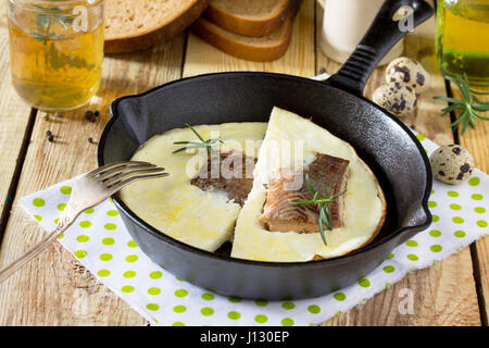 Omelette mit roter Fisch in einer gusseisernen Pfanne. Stockfoto
