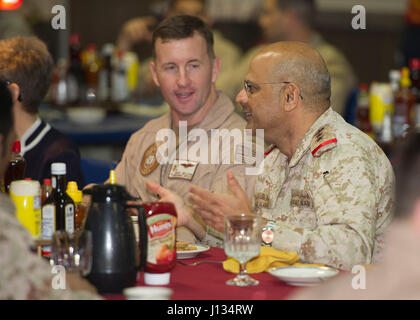 Persischen Golf (15. März 2017) USS Makin Island (LHD 8) Kommandierender Offizier, Captain Mark A. Melson, links, spricht mit Kuwait Navy Oberst Nayef al-Askar, beim Mittagessen in der Offiziersmesse auf amphibischer Angriff Schiff. Makin Island in die USA eingesetzt ist 5. Flotte Bereich der Maßnahmen zur Erhöhung der Sicherheit im Seeverkehr Operationen, Verbündete und Partner zu beruhigen, und die Freiheit der Schifffahrt und den freien Fluss des Handels in der Region zu erhalten. (Foto: U.S. Navy Lt. David Gardner) Stockfoto