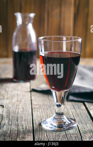Glas Rotwein auf Holztisch. Stockfoto