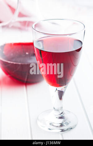 Glas Rotwein auf weißen Tisch. Stockfoto