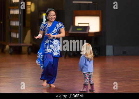 Seattle, Washington: Museum of History & Industrie. Tänzer aus Kultur Shakti mit einem jungen Besucher im großen Atrium während Familientag mit Festál. Stockfoto