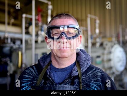 Darryl Hodge, 733rd Logistik Bereitschaft Squadron Brennstoffe Einrichtungen Kraftstoffe Verteilung Systeme Operator, posiert für ein Foto auf gemeinsamer Basis Langley-Eustis, Virginia, 10. April 2017. Brennstoffe Einrichtungen Flieger tragen eine Schürze, Handschuhe und Googles zum Schutz vor Verschmutzungen, die während der Brennstoffe Probenahme Prozess auftreten. (US Air Force Foto/Staff Sgt. Areca T. Bell) Stockfoto