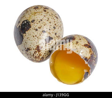 zwei braune gefleckte Wachteleier mit einem geöffneten in weißem Rücken Stockfoto