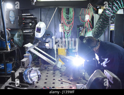 170411-N-DW433-060 YOKOSUKA, Japan (11. April 2017) Rumpf Wartung Techniker Feuerwehrmann Tristian E. Daugherty, links, von De Soto, Mo., verbunden in die US 7. Flotte Flaggschiff USS Blue Ridge (LCC-19), schleift einen Fernsehen-Gurt beim Rumpf Maintenance Technician 3. Klasse Thomas Dwyer aus Florham Park, NJ, schweißt einen Amboss. Blue Ridge ist in einer umfangreichen Wartungsperiode um das Schiff zu dienen als robust Kommunikations-Plattform in den USA weiterhin modernisieren 7. Flotte Einsatzgebiet. (Foto: U.S. Navy Masse Kommunikation Spezialist Seemann Lehrling Angeles A. Miron / RELEASE Stockfoto