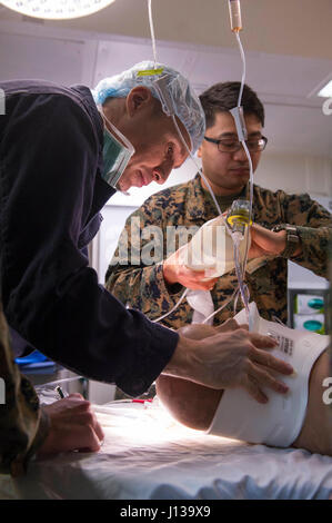 170411-N-FO981-0075 Pazifik (11. April 2017) Lt. CMdR Anthony Duran, Flotte chirurgischen Team 1, zugewiesen führt eine Untersuchung des Patienten auf dem amphibischen Angriff Schiff USS America (LHA 6) während einer geplanten Unfall-Evakuierung-Drill. Amerika ist im Gange mit mehr als 1.000 Matrosen und 1.600 Marinesoldaten, die Durchführung von amphibischen Geschwader und Marine expeditionary Unit Integration Operationen in Vorbereitung auf das Schiff ersten operativen Einsatz noch in diesem Jahr. (Foto: U.S. Navy Mass Communication Specialist 3. Klasse Jacob Holloway/freigegeben) Stockfoto