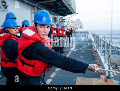 170411-N-SU012-0038 Pazifik (11. April 2017) Seemann Adam Jones, gebürtig aus Detroit, führt eine Gruppe von Matrosen auf einem Telefon und Entfernung Linie während der Betankung auf See an Bord der amphibischen Angriff Schiff USS America (LHA-6). Amerika ist derzeit mit mehr als 1.000 Matrosen und 1.600 Marines Durchführung von amphibischen Geschwader/Marine Expeditionary Unit Integration Operationen in Vorbereitung auf das Schiff Jungfernfahrt Bereitstellung noch in diesem Jahr in Angriff genommen. (Foto: U.S. Navy Mass Communication Specialist 3. Klasse William A. Pinckney/freigegeben) Stockfoto