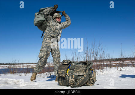 Sgt. Paul Mampreian, gebürtig aus Chicago, Ill., 1. Bataillon, 501st Fallschirm-Infanterie-Regiment, 4th Infantry Brigade Combat Team (Airborne), 25. Infanterie-Division, U.S. Army Alaska zugewiesen lädt seinen Sprung Gang nach Durchführung von Luftlandeausbildung an gemeinsame Basis Elmendorf-Richardson, Alaska, 13. April 2017. Die Soldaten des 4/25 gehören zu der einzige amerikanische airborne Brigade im Pazifik und sind darauf trainiert, in der Luft Manöver in extrem kalten Wetter/Höhen Umgebungen zur Unterstützung der Kampf, Partnerschaft und Disaster Relief-Operationen ausführen. (U.S. Air Force Photo von Alejandro Pena) Stockfoto