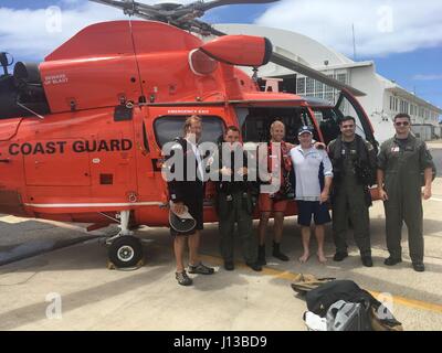 Die Crew ein Coast Guard MH-65 Dolphin-Helikopter von Air Station Borinquen nimmt ein Foto mit geretteten Bootsfahrer, Kirk Plender aus New Hampshire und John Boone aus South Carolina, nach der Rettung der Bootsfahrer eine Rettungsinsel 13. April 2017.  Die Segler mussten 62-Fuß-Segelschiff Ocean Quest aufzugeben, die in Silber Banken, rund 80 Seemeilen nördlich oder Puerto Plata, Dominikanische Republik sank. Stockfoto