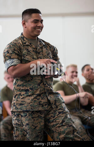 US Marine Corps Sgt. William Biagas, Militärpolizei, mit Sitz und Support Battalion (H & S BN), Marinekorps Installationen Pacific (MCIPAC), feuert eine X26 Taser auf Fellow Marine beim Sicherheit Augmentation Force (SAF) Training am Camp Kinser, Okinawa, Japan, 13. April 2017. Marines während H & S BN, MCIPAC, Freiwillige zu SAF zertifiziert, um der Provost Marshal Büro bei Bedarf zu unterstützen. (Foto: U.S. Marine Corps MCIPAC Bekämpfung der Kamera Lance Cpl. Christian J. Robertson) Stockfoto