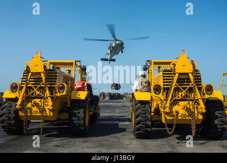 Ein MH-60S Seahawk Helikopter von HSC-21 Blackjacks lieferte während einer vertikalen Auffüllaktion im Südchinesischen Meer am 13. April 2017 Vorräte an die USS Makin Island, um die 11. Marine Expeditionary Unit und die amphibische Bereitschaft mit regionalen Partnern zu unterstützen. Stockfoto