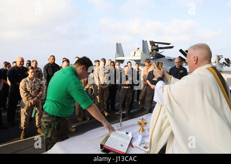 170416-N-UM082-041 Golf von ADEN (16. April 2017) Kaplan, Lt. CMdR Jay Kersten führt einen besonderen Easter Sunrise Service auf dem Flugdeck der amphibischen Angriff Schiff USS Bataan (LHD-5). Das Schiff und seine bereit-Gruppe sind in den USA im Einsatz 5. Flotte Bereich der Maßnahmen zur Erhöhung der Sicherheit im Seeverkehr Operationen, Verbündete und Partner zu beruhigen, und die Freiheit der Schifffahrt und den freien Fluss des Handels in der Region zu erhalten. (Foto: U.S. Navy Mass Communication Specialist 3. Klasse Raymond Minami/freigegeben) Stockfoto