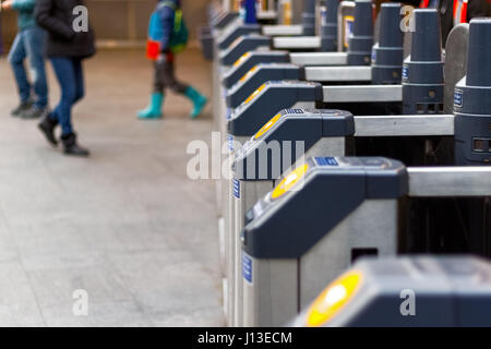 London, UK - 28. Februar 2017 - Ticket Barriere am Kings Cross Station mit Passanten im Hintergrund Stockfoto