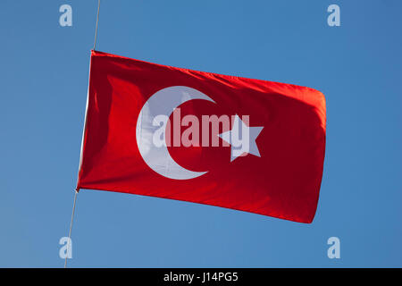 Türkische Flagge gegen blauen Himmel Stockfoto