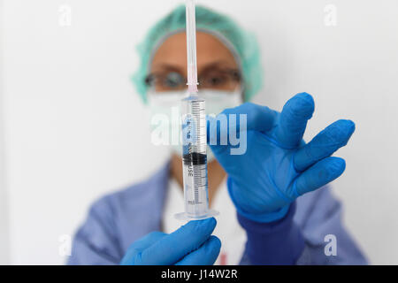 Eine Arzt Krankenschwester mit Handschuhen hält eine Spritze Stockfoto