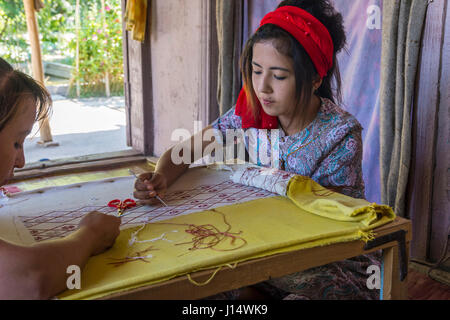 MARGILAN, Usbekistan - 20 AUGUST: Frau Sticken Stoff von hand mit traditionellen usbekischen Mustern in eine Seidenfabrik Werkstatt. August 2016 Stockfoto