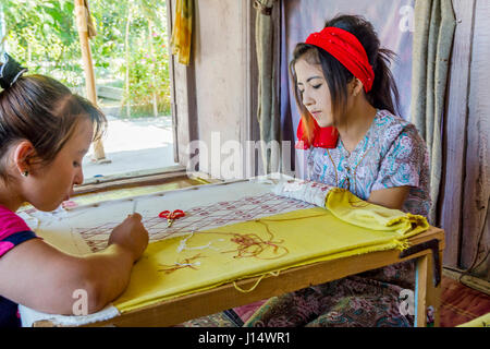 MARGILAN, Usbekistan - 20 AUGUST: Frau Sticken Stoff von hand mit traditionellen usbekischen Mustern in eine Seidenfabrik Werkstatt. August 2016 Stockfoto