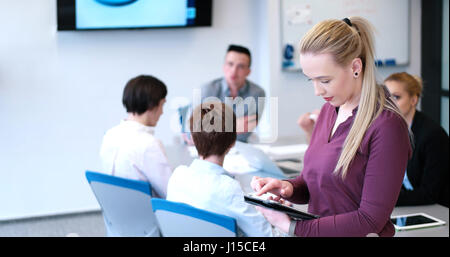 Business-Frau mit Digital-Tablette in geschäftiges Büro Stockfoto