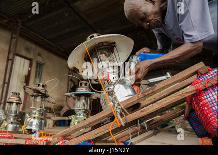 Ein Fischer gießt Kerosin in einer Lampe für Nachtangeln für Sardinen oder lokal bekannt als Buka-Buka, am Tanganjikasee, Sambia Stockfoto