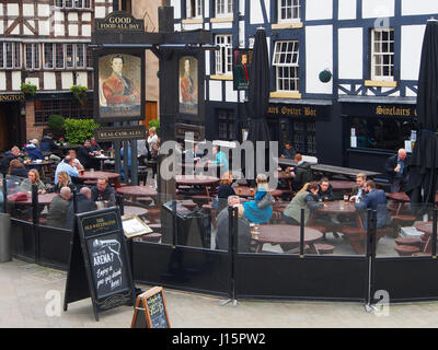 Menschen entspannen mit einem Getränk und Essen außerhalb der Sinclairs Oyster Bar und das alte Welllington Inn im Zentrum von Manchester, England, UK. Stockfoto