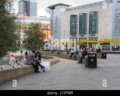Exchange Square im Zentrum von Manchester, England, Menschen sitzen, warten und entspannen mit der bunten bunte Tram-Station in der b/g zu zeigen. Stockfoto
