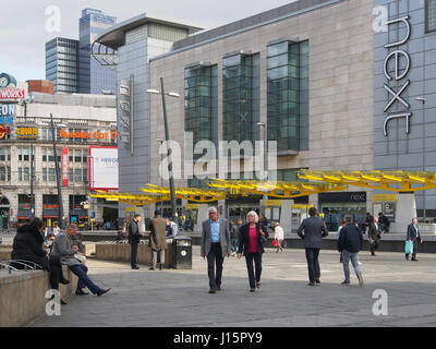 Exchange Square im Zentrum von Manchester, England, Menschen sitzen, warten und entspannen mit der bunten bunte Tram-Station in der b/g zu zeigen. Stockfoto