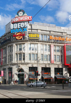 Exterieur der Printworks Veranstaltungsort im Zentrum von Manchester Stadtzentrum, zeigt die bunte Werbung Logos vor blauem Himmel. Stockfoto