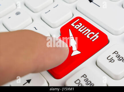 Finger eine Raketen-Start-Taste auf einer Computertastatur drücken. Stockfoto