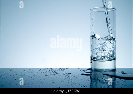 Spritzwasser aus Glas mit Exemplar und blau getönt Stockfoto