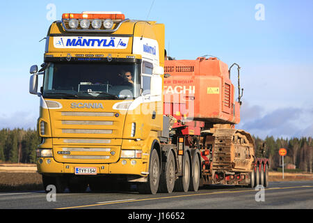 JOKIOINEN, Finnland - 29. Oktober 2016: Scania R620 Sattelschlepper von Mantyla schleppt große nachverfolgten Hitachi-Bagger auf Tieflader Anhänger auf Autobahn so breit Stockfoto