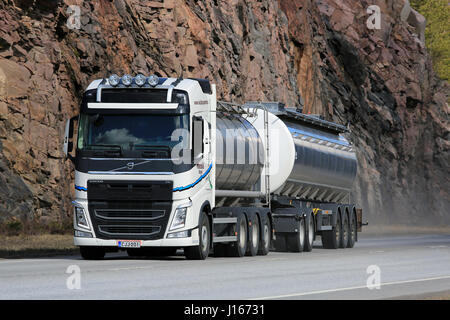 KARJAA, Finnland - 10. April 2016: Neue, weiße Volvo FH Tankwagen auf bewegt entlang der Autobahn, mit Felswand im Hintergrund. Stockfoto