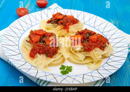 Pasta Nest Tagliatelle mit Bolognese-Sauce und Gemüse auf einem Teller. Stockfoto