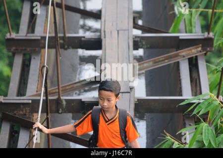 JAVA, Indonesien: Balancieren auf zehn-Zoll-breiten Holzlatten diese Kinder muss eine prekäre 100 Fuß langen Stahlseil-Brücke auf ihre ZUVORKOMMENHEIT nur bis zur Schule überqueren. Wenn Sie, Ihre Schule Lauf dachten war ein Alptraum-Spare ein Gedanke für diese Kinder, die so ihre Ausbildung, die sie bereit sind gewidmet sind zu riskieren, Leib und Leben auf ihre tägliche Mission, um ins Klassenzimmer. Lokalen Fotografin Agoes Rudianto (28) hat die Bilder von Kindern aus der Stadt Boyolali, Java, Indonesien reisen. Stockfoto