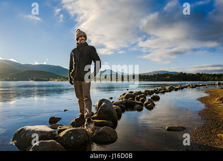 Ein Mann steht am See in den schottischen Highlands Stockfoto