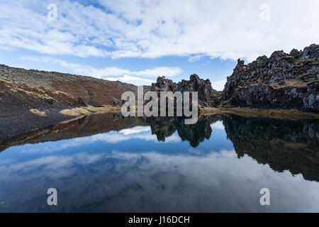 Reflexionen in einem See umgeben von Lava-Formationen. Djúpalónssandur schwarzen Sandstrand, Halbinsel Snaefellsnes (Snaefellsnes), West-Island Stockfoto