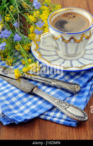 antike Kaffeetasse mit alten Besteck und Bündel von Vergiss mich nicht Blumen. Stockfoto