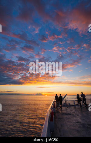 Silhouette Passagiere Uhren den Sonnenuntergang aus dem oberen Deck eines Schiffes British Columbia Ferry Stockfoto