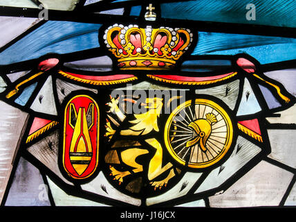 Glasfenster in der Kirche von Tervuren, Belgien, Darstellung der belgischen Löwen, eine Rakete und ein Helm und Rad Stockfoto