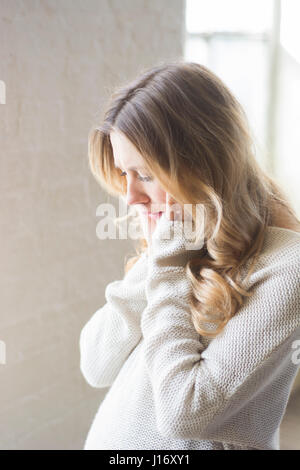 Seitenansicht einer gestressten jungen Frau Hände Gesicht berühren Stockfoto