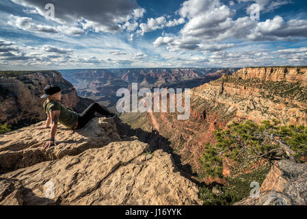 Grand Canyon und ein junger Wanderer auf der Felge sitzen und die Aussicht genießen. Stockfoto