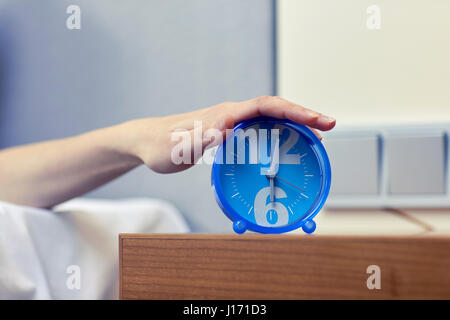 Nahaufnahme von Hand auf Wecker im Schlafzimmer Stockfoto