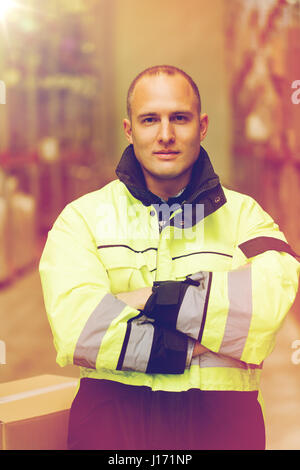 Mann in Overalls mit Box am Lager Stockfoto